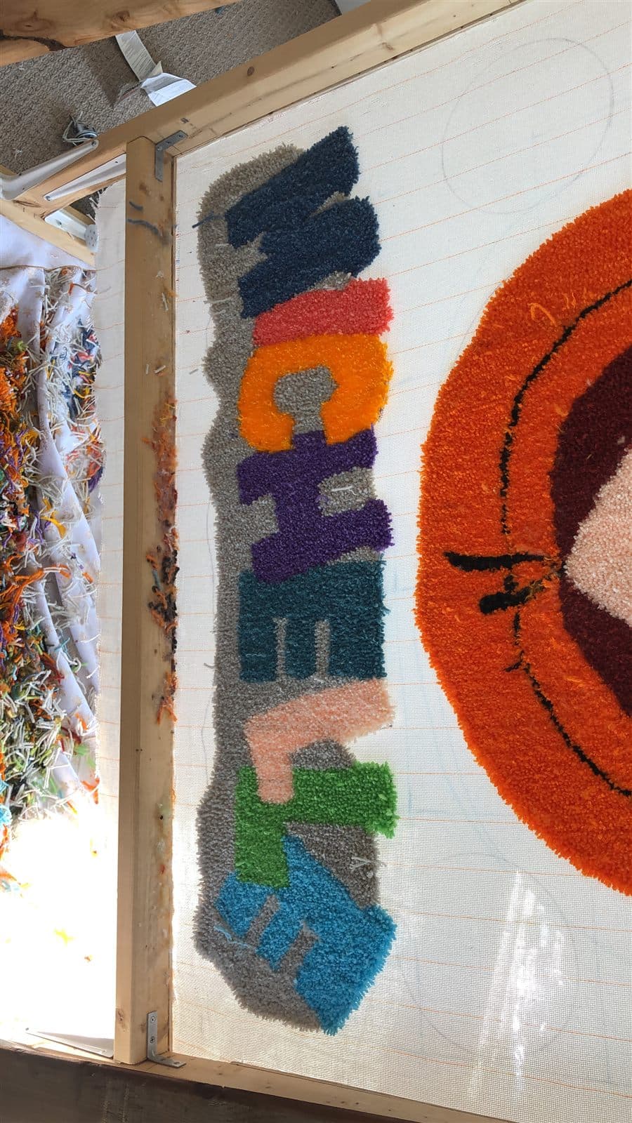 A name rug being tufted on the frame
